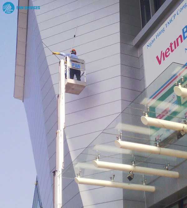 Nhân viên Pan Services Hà Nội vệ sinh kính mặt dựng với sự hỗ trợ của thang nâng